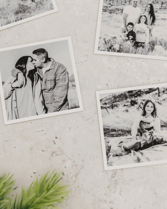 Close-up of black and white custom photo magnets with matte finish displayed on a light textured wall.