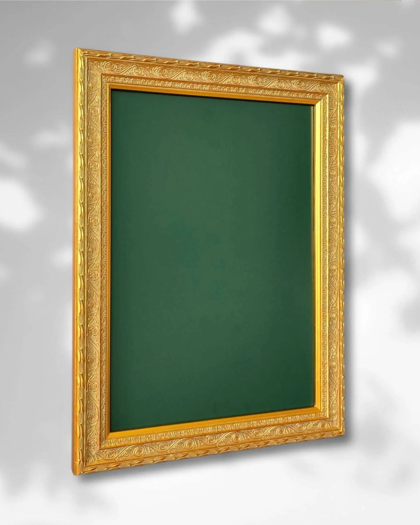 Vintage gold framed magnetic board with green steel surface mounted on a neutral wall background