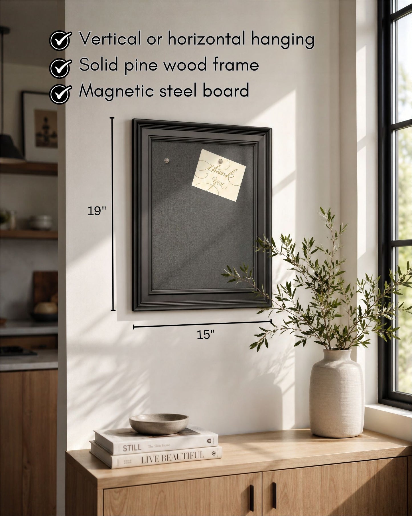 Modern black magnetic board with solid pine wood frame displayed in a bright kitchen, featuring vertical or horizontal hanging, magnetic steel surface, and 15x19 inch dimensions.