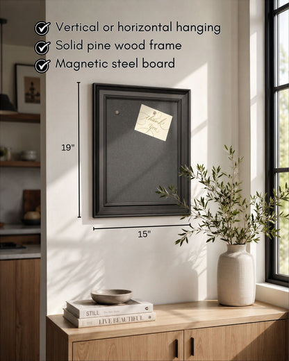 Modern black magnetic board with solid pine wood frame displayed in a bright kitchen, featuring vertical or horizontal hanging, magnetic steel surface, and 15x19 inch dimensions.