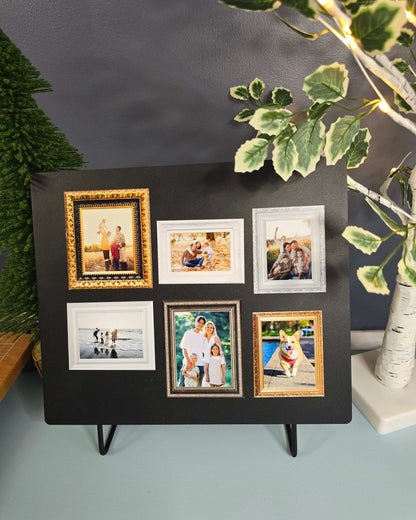 Black photo album with multiple framed photos on a gray surface with greenery.