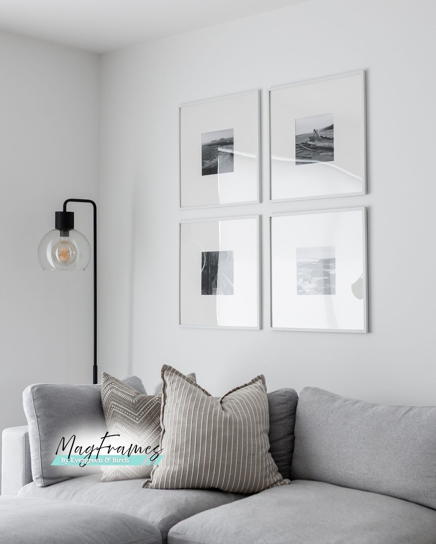 Four 20x20 white MagFrames with plexiglass displayed above a gray sofa in a clean modern living room.