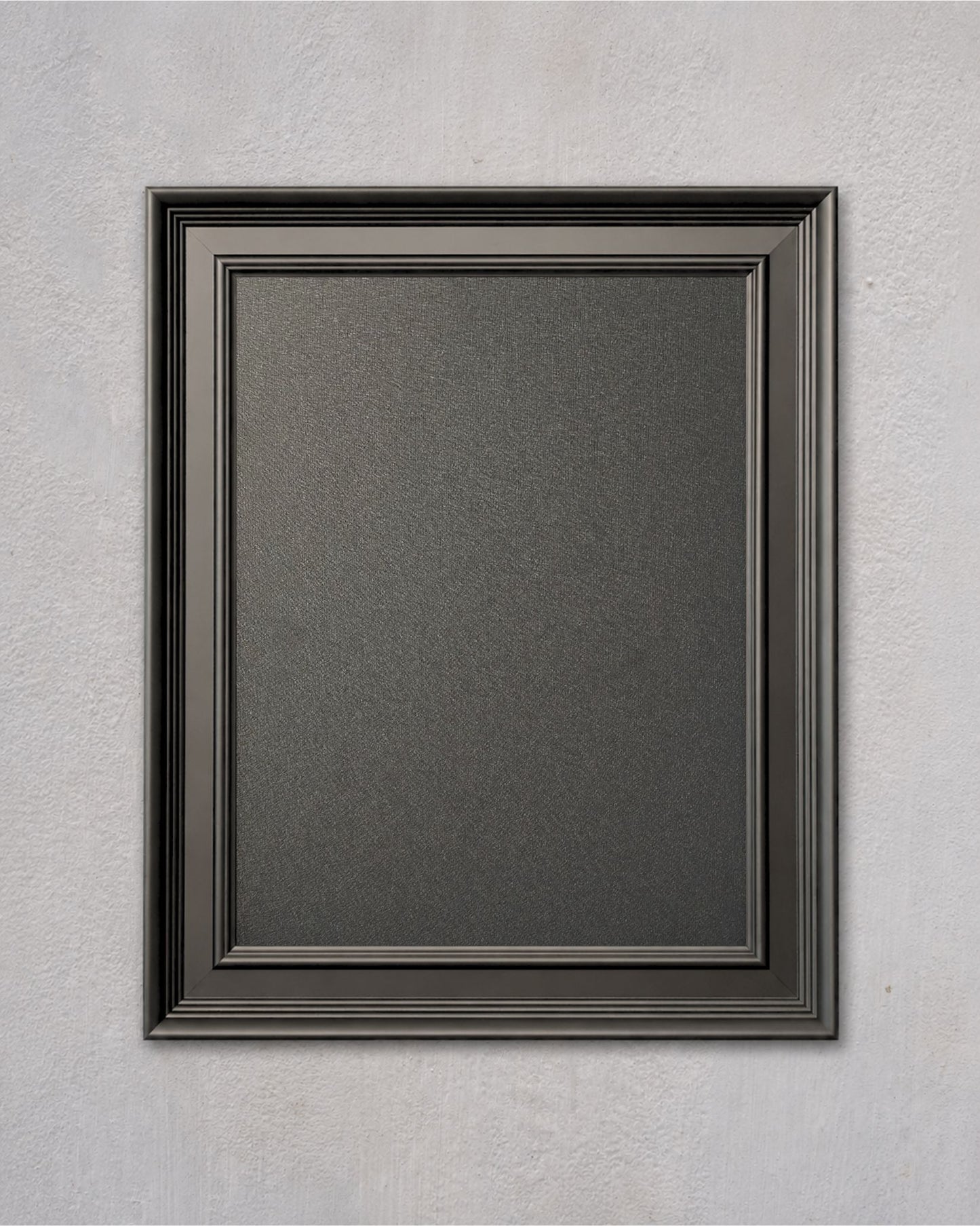 Dark graphite magnetic board with a modern black solid wood frame mounted on a light textured wall.
