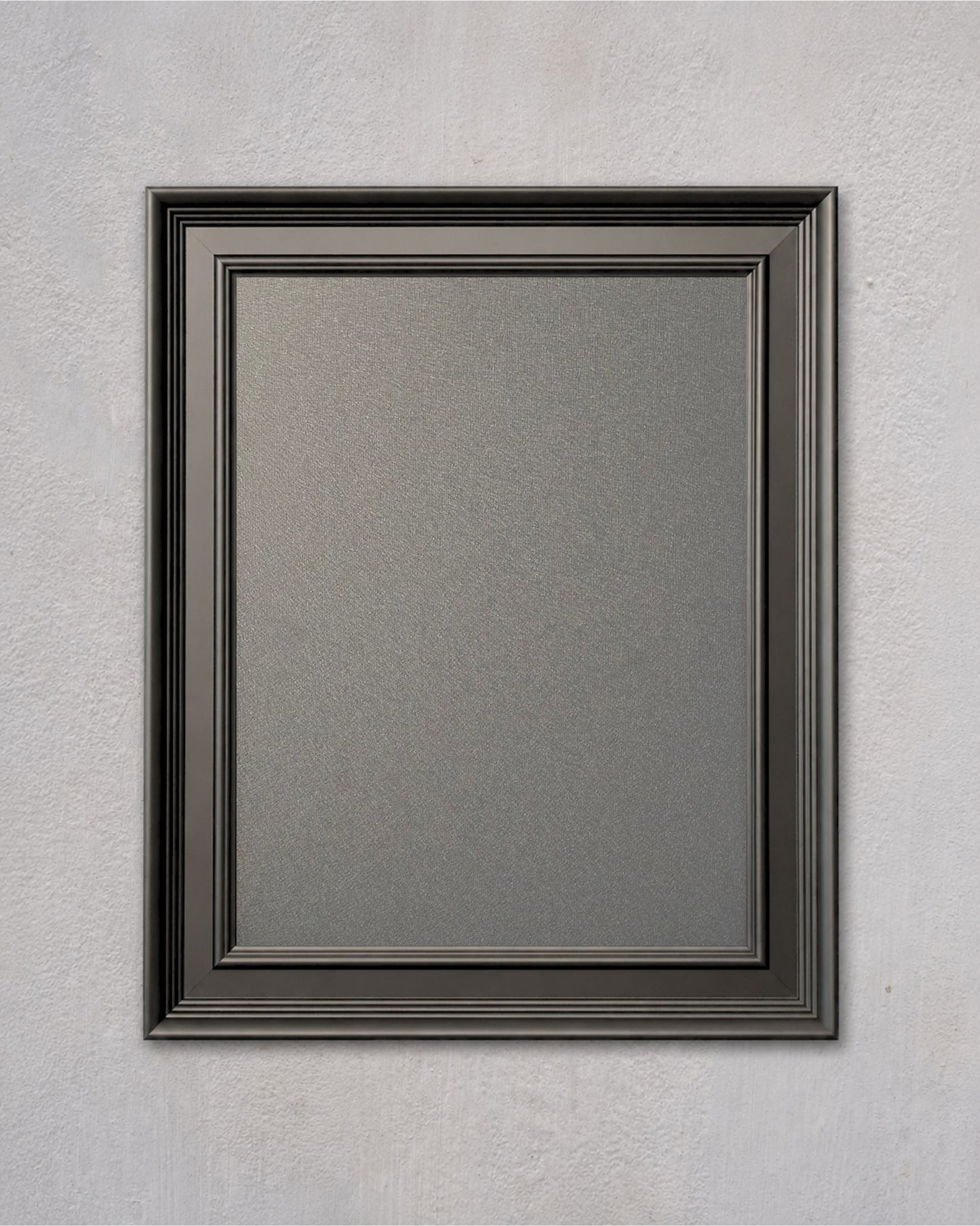 Modern black magnetic board with a solid pine wood frame and powder-coated magnetic steel surface mounted on a light gray textured wall.