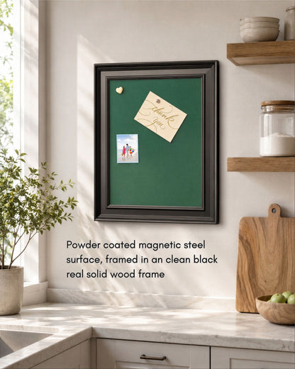Royal green magnetic board with a modern black solid wood frame mounted in a bright kitchen, featuring pinned notes and photos on a powder-coated magnetic steel surface.
