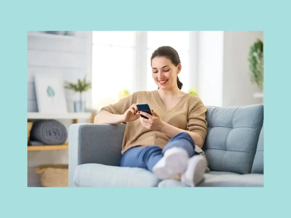 Woman selecting photos on phone to upload for magnetic photo frames in Canada